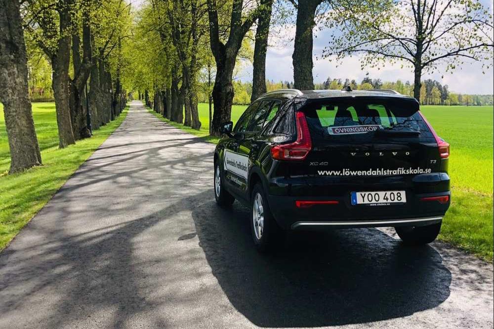 Svart bil med en övningskörningsskylt