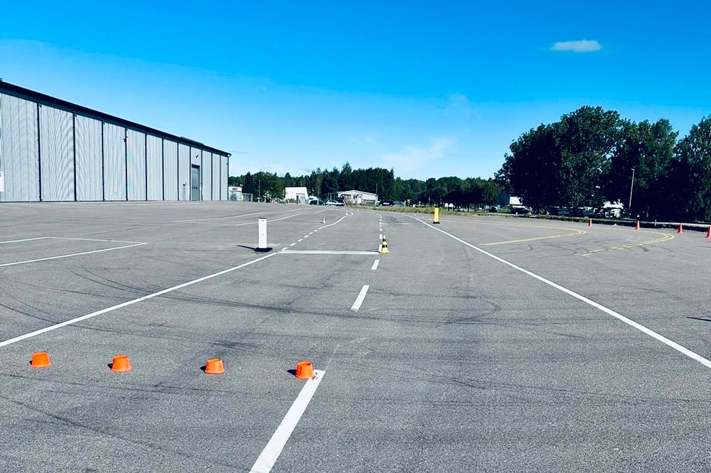 Fem orangea trafikkoner är uppställda i en rad längs en av linjerna, troligen för körövningar