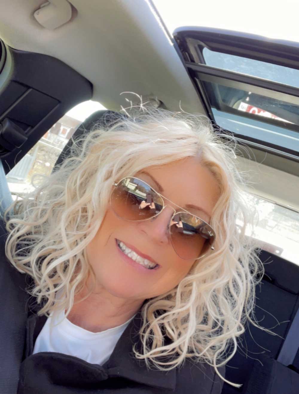 Blond kvinna i bil ler